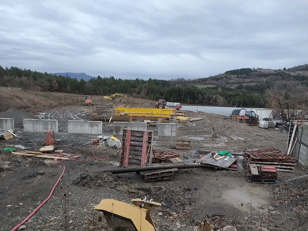 Plateforme terrassée et première levée de voiles sur un terrain boueux à Upaix