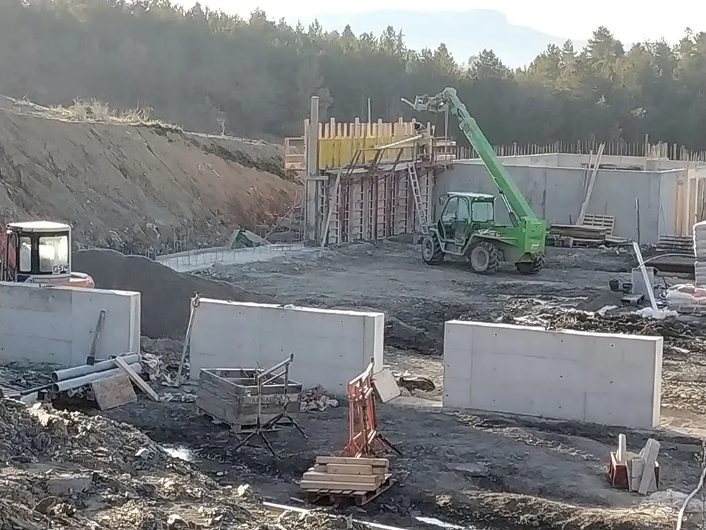 Banches métalliques en place pour couler un mur en béton armé sur un chantier agricole à Upaix