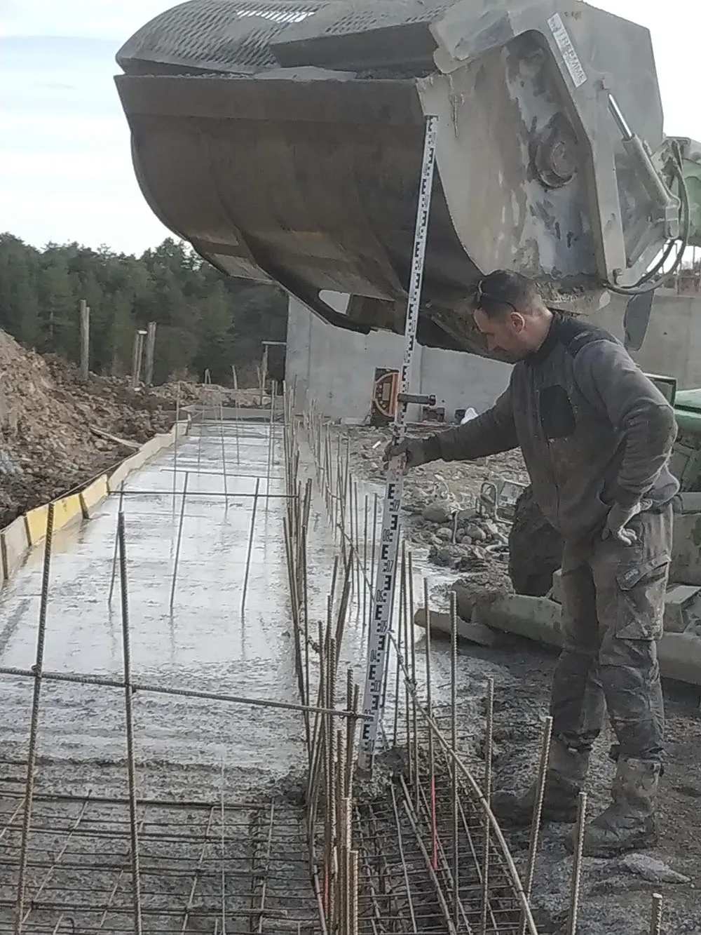 Contrôle de la hauteur du béton frais à la mire sur une semelle filante à Upaix