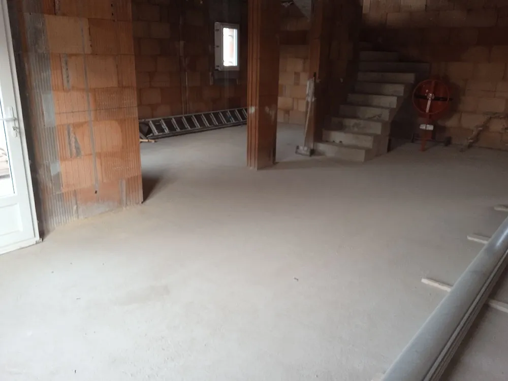 Plancher béton hourdis isolants et chape coulée au rez-de-chaussée d'une villa RE2020 à Château-Arnoux