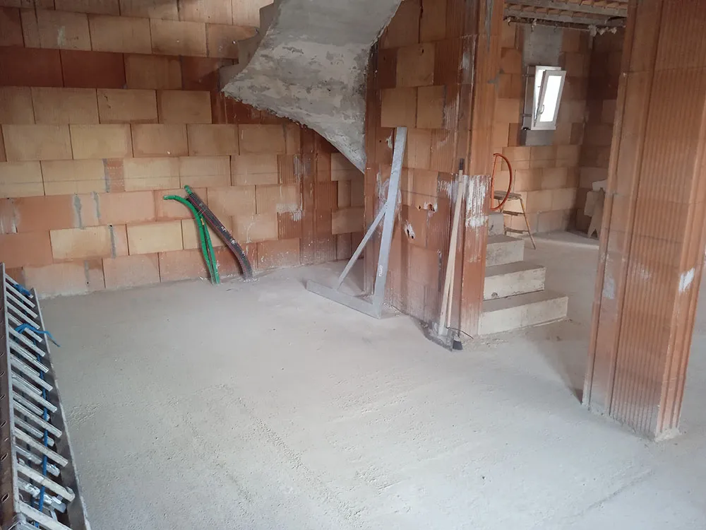 Rez-de-chaussée brut en briques avec escalier béton et gaines, villa en construction à Château-Arnoux